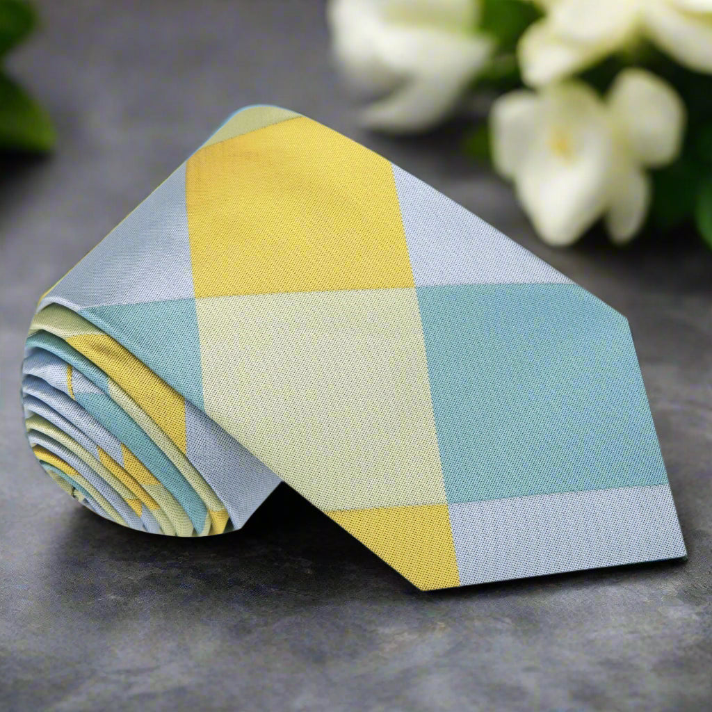 Close-up of the Sun-Drop Diamond Silk Tie showcasing the intricate blue and yellow diamond pattern.
