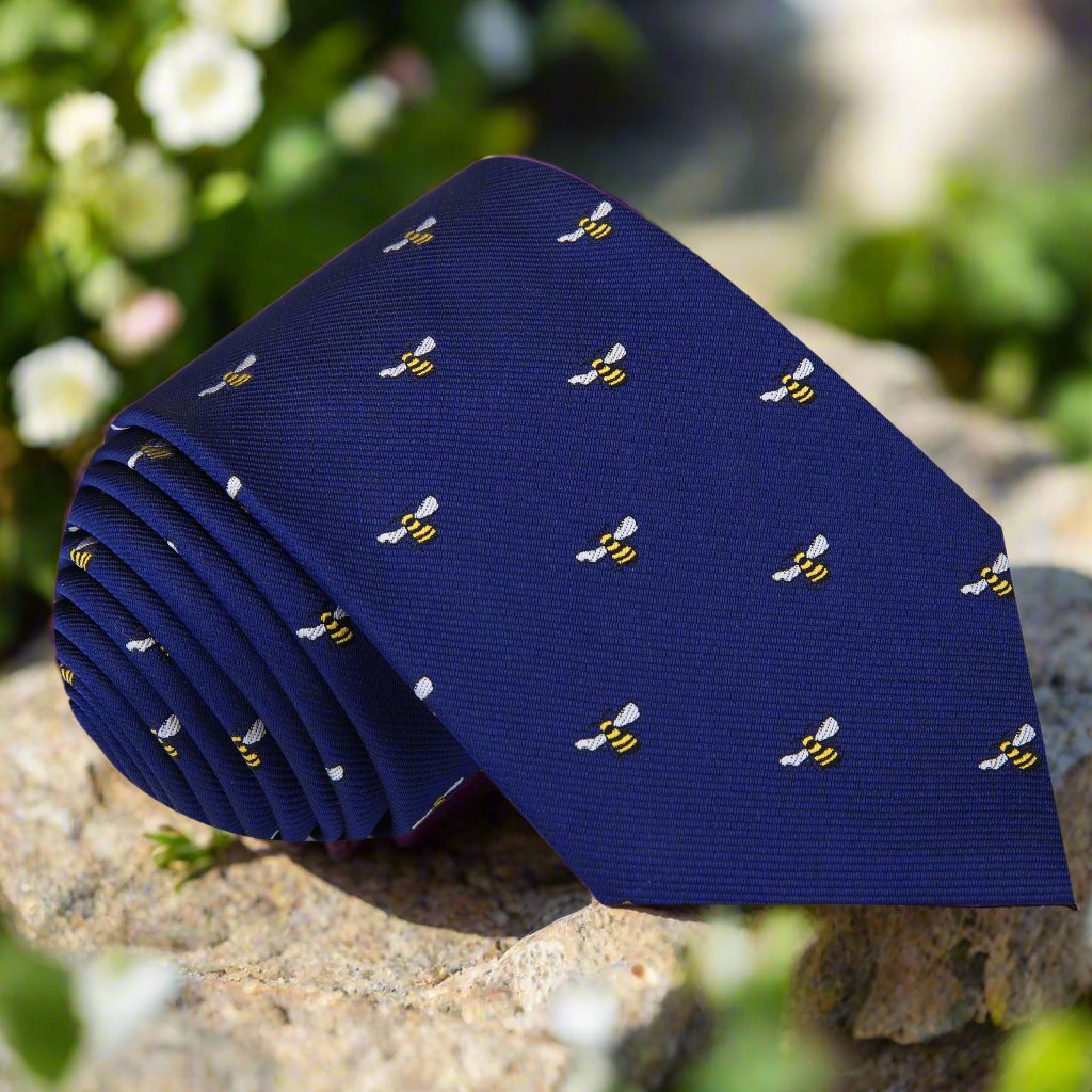 Close-up of blue silk necktie with bee pattern, perfect for wedding attire