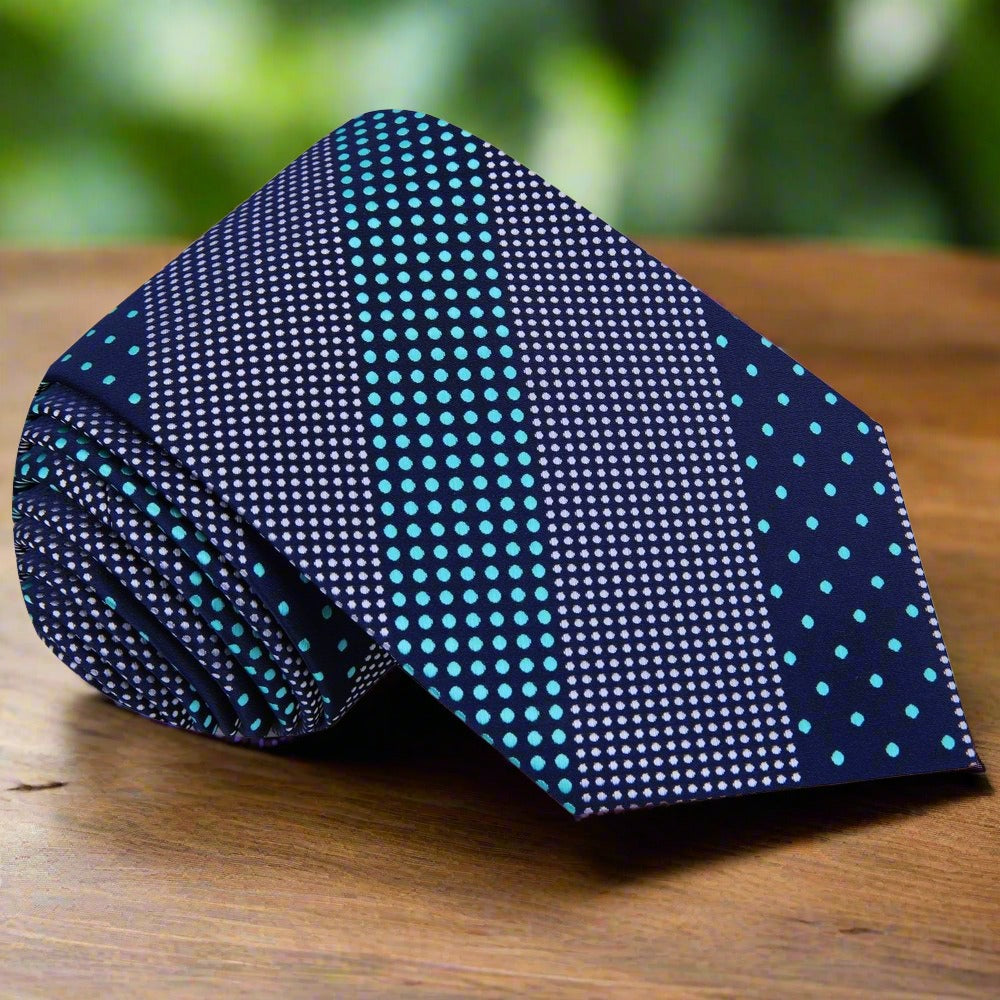 Silk polka dot tie laid flat against a white background showing the full pattern and dark blue tones
