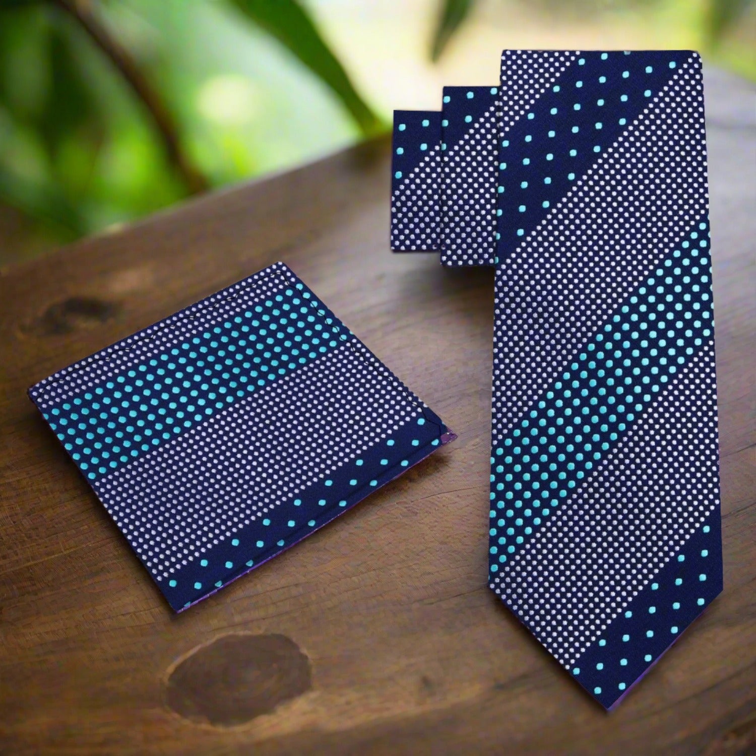 Silk polka dot tie laid flat against a white background showing the full pattern and dark blue tones