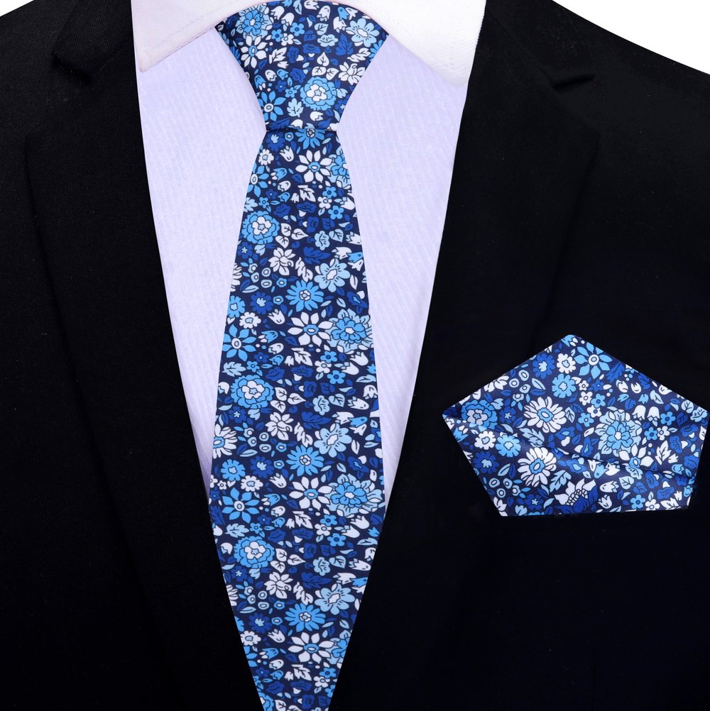Model wearing a floral silk necktie with a white dress shirt and navy suit