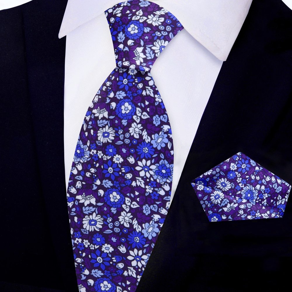 Model wearing a floral silk necktie with a white dress shirt and navy suit