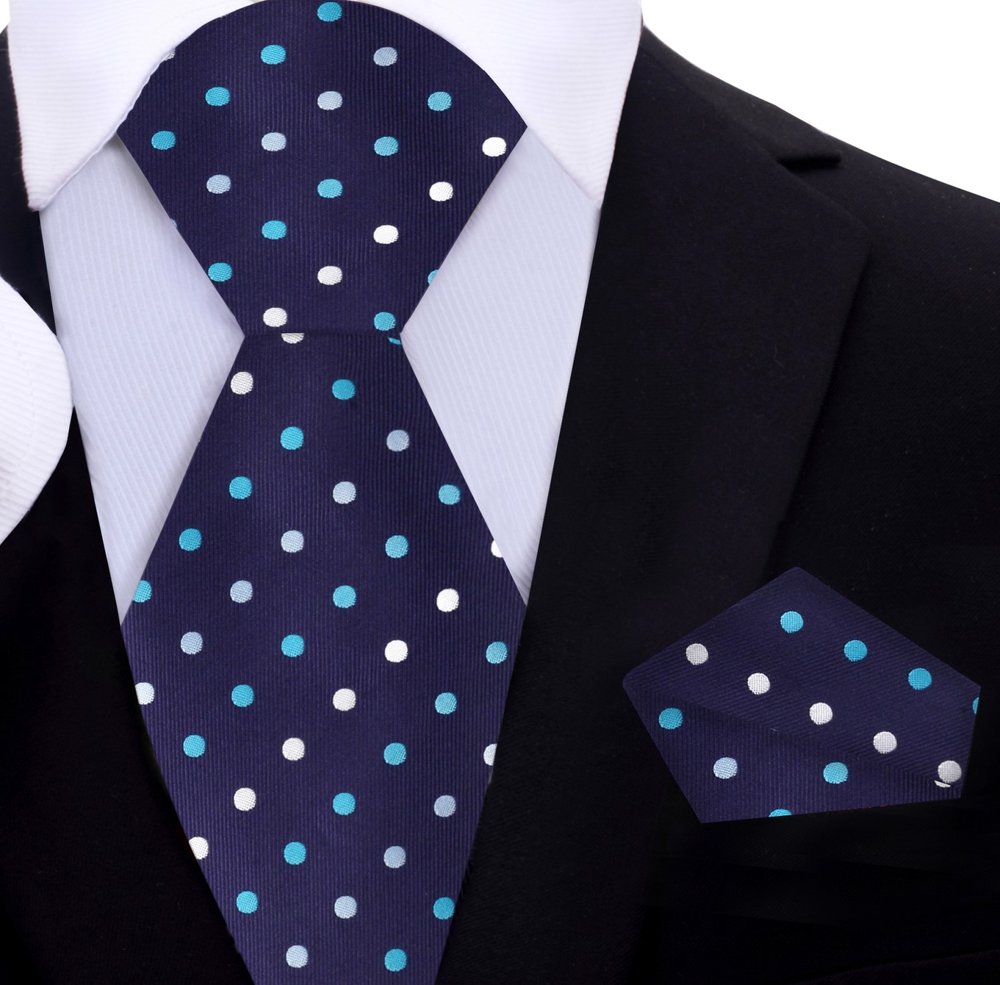 Man wearing a stylish polka dot silk tie with a navy suit at a formal event