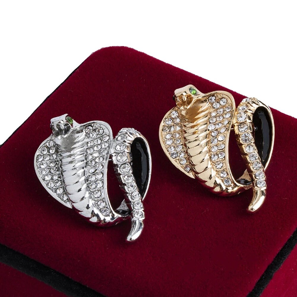 Close-up of gold cobra lapel pin with clear stones on a white dress shirt