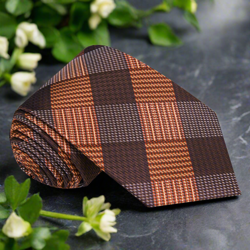 Close-up of the Autumn Harmony Plaid Silk Tie showcasing its intricate orange and brown pattern.