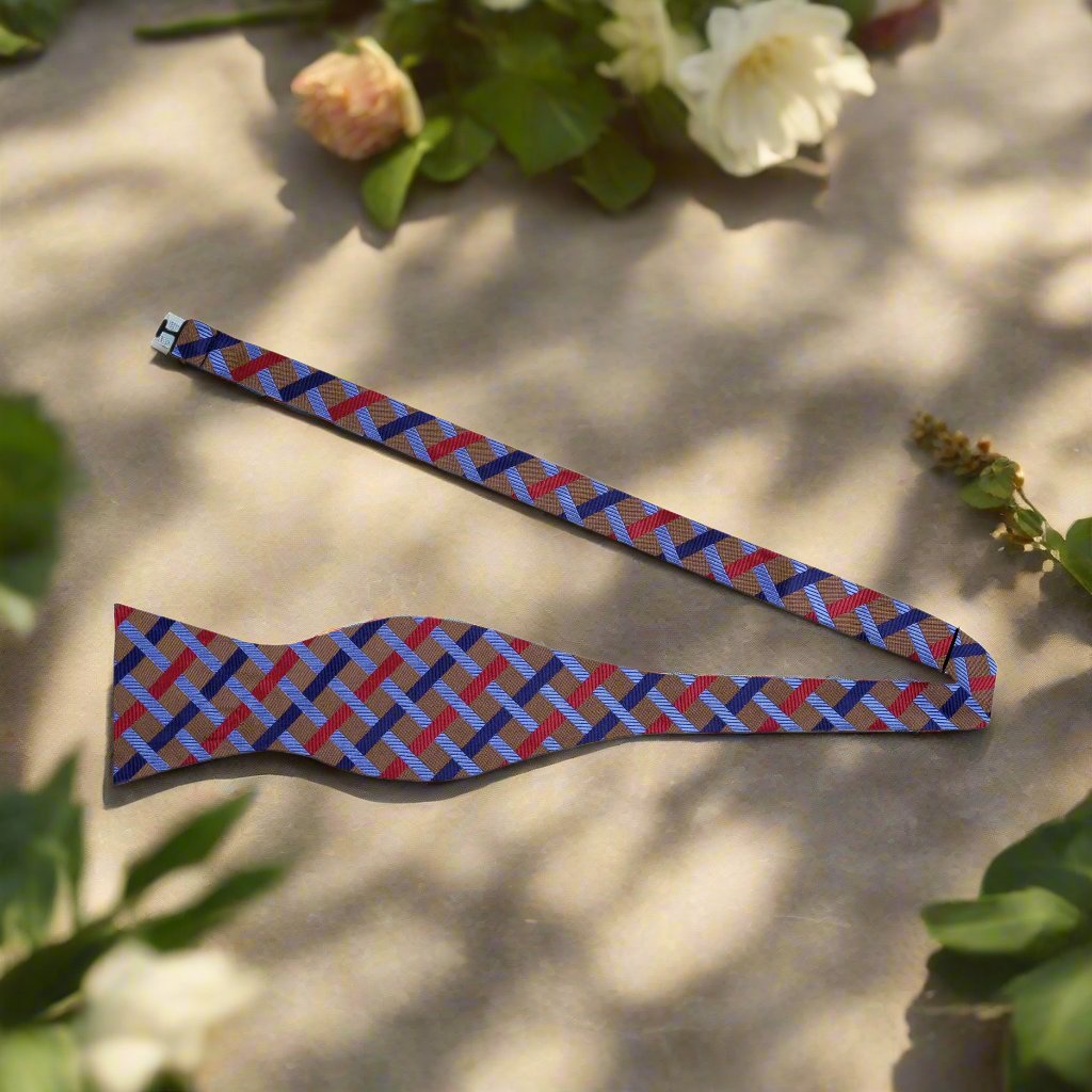 Close-up of a luxury geometric silk bow tie in rich brown, red, and blue hues, perfect for weddings