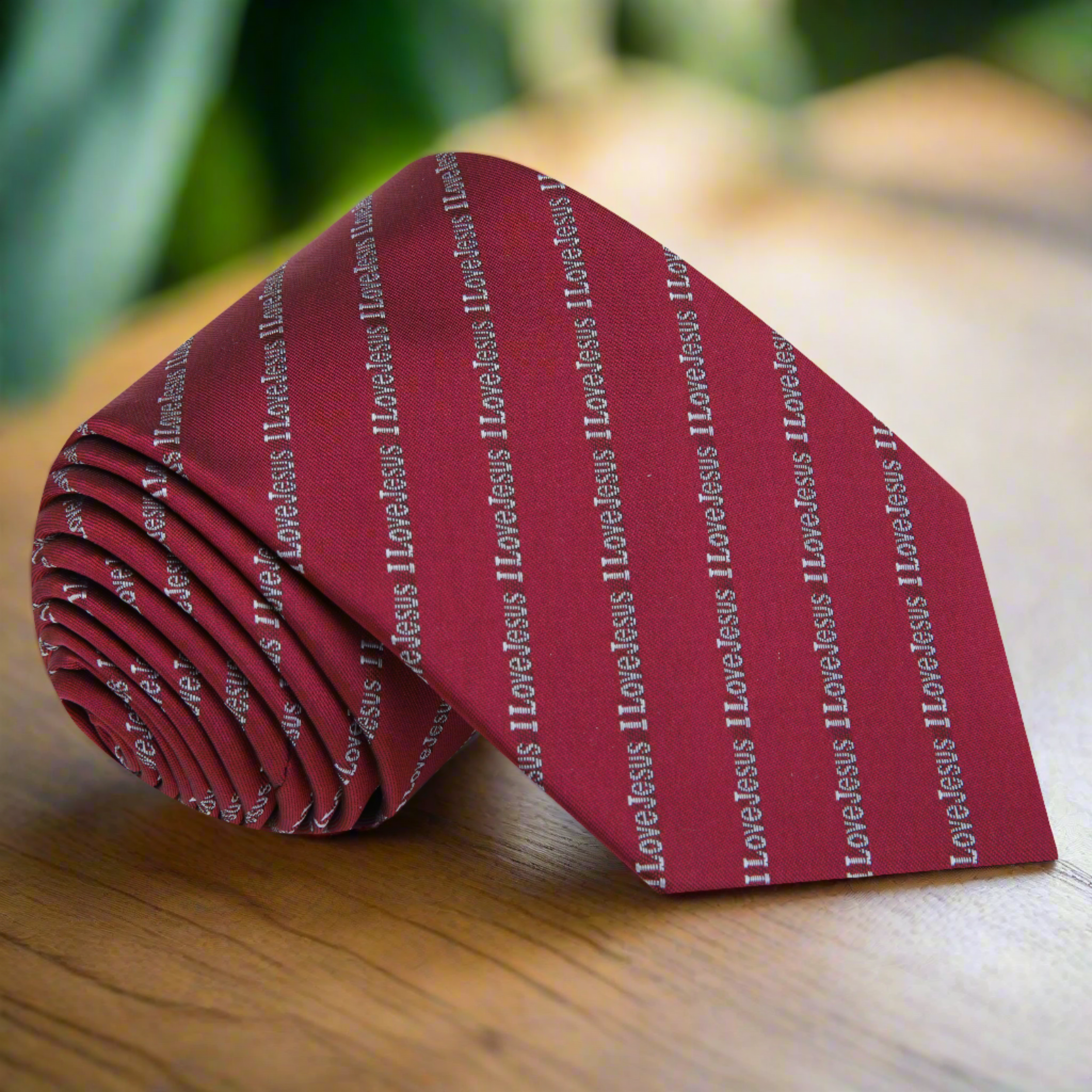 Close-up of Carmine red 'I Love Jesus' silk necktie hanging on a suit, perfect for church attire