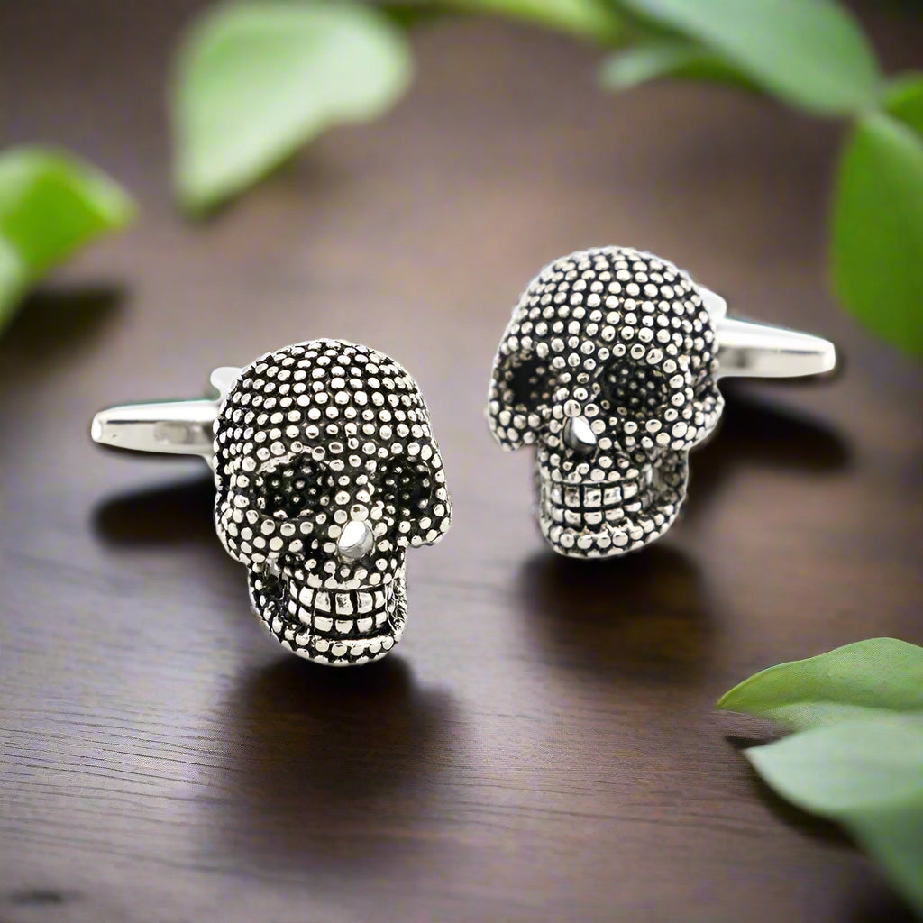 Close-up of gothic skull cufflinks with chrome finish and gem detailing