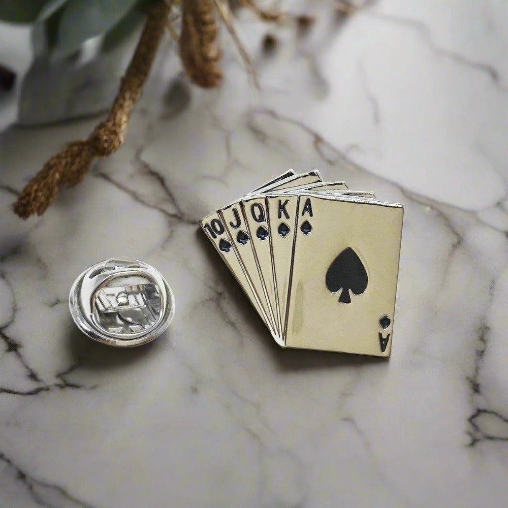 Close-up of chrome royal flush lapel pin on black dress shirt, ideal for formal events