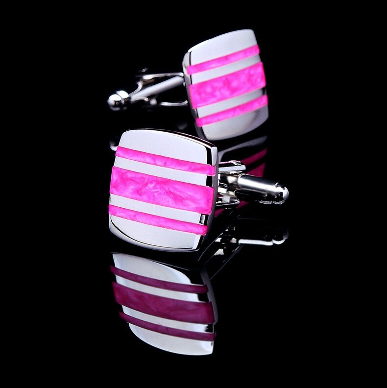 Close-up of chrome cufflinks with red stone against a black background