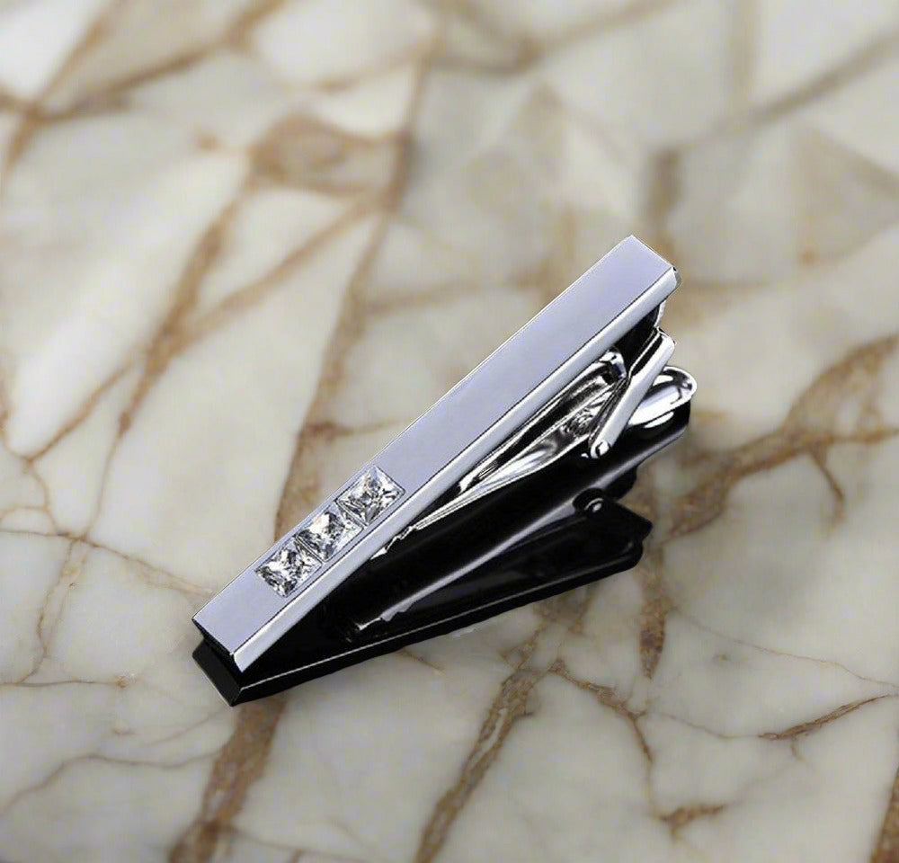 Cuff links laid out next to the tie bar showcasing their sleek design