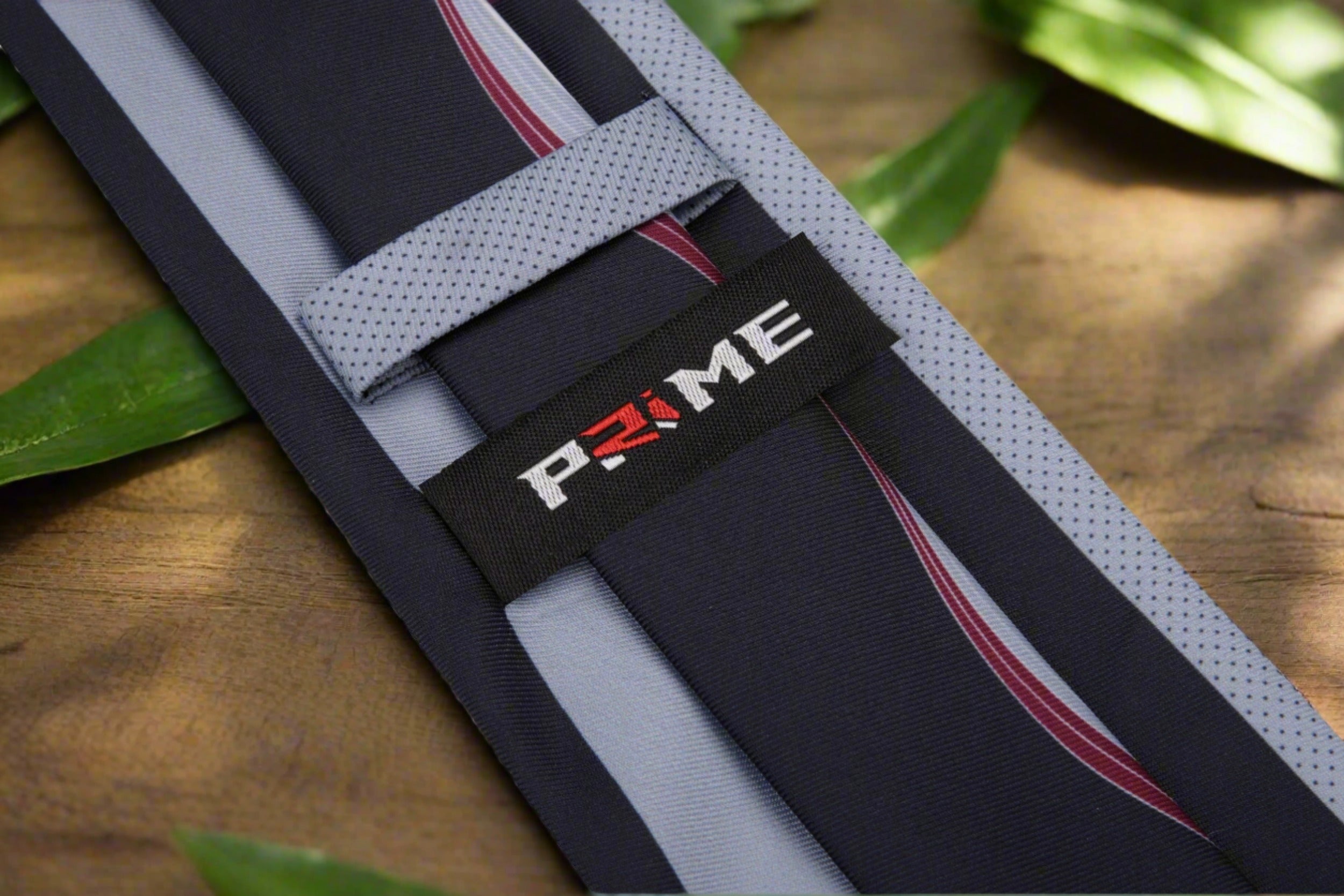 Detailed shot of the silk tie draped over a light grey dress shirt, highlighting its elegant design.