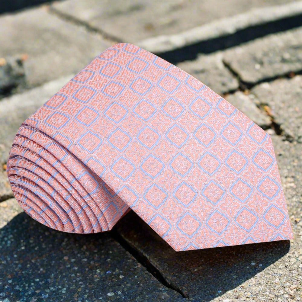 Peach geometric silk tie worn with a crisp white dress shirt for a formal look.