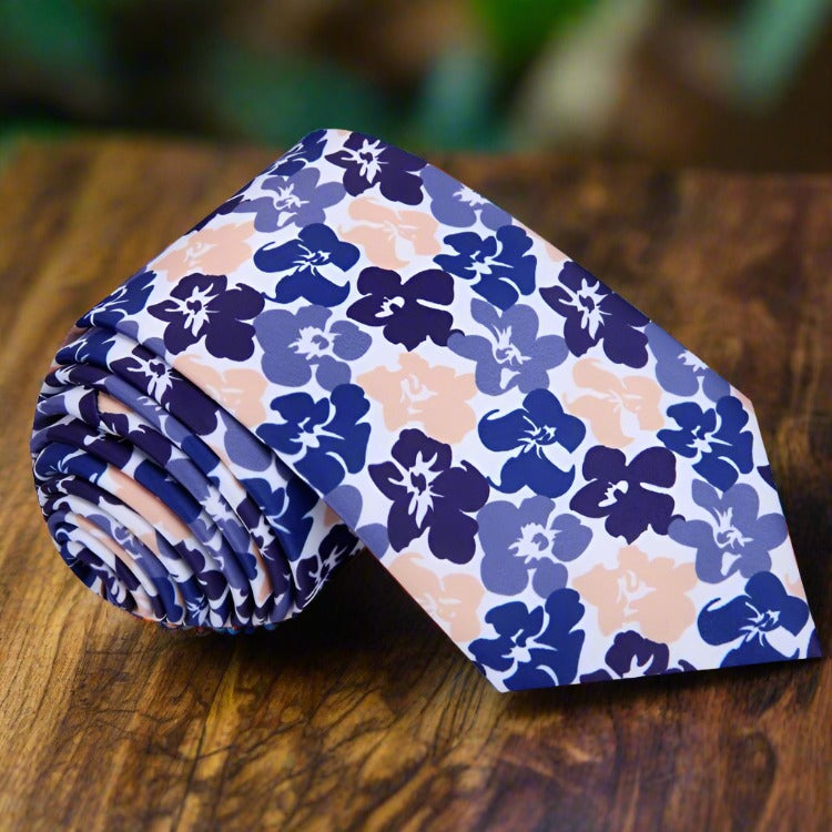 Tropical hibiscus floral silk tie displayed on a wooden surface, showcasing its vibrant colors and elegant design.