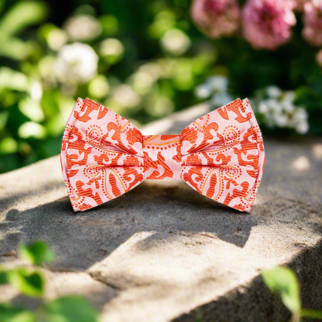 Close-up of the vibrant orange paisley bow tie showcasing its intricate design.