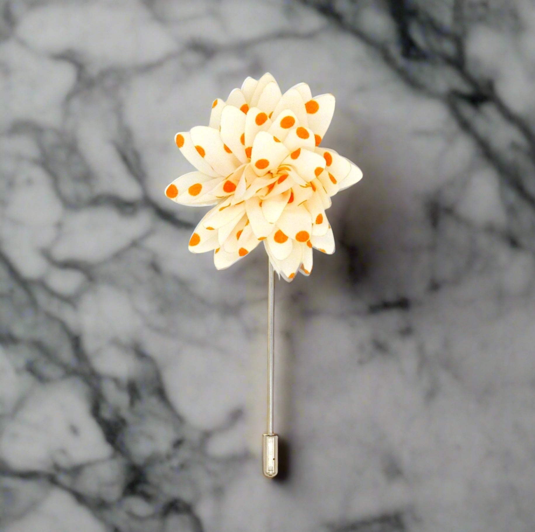 Close-up of charming cream and orange floral lapel pin showcasing intricate details