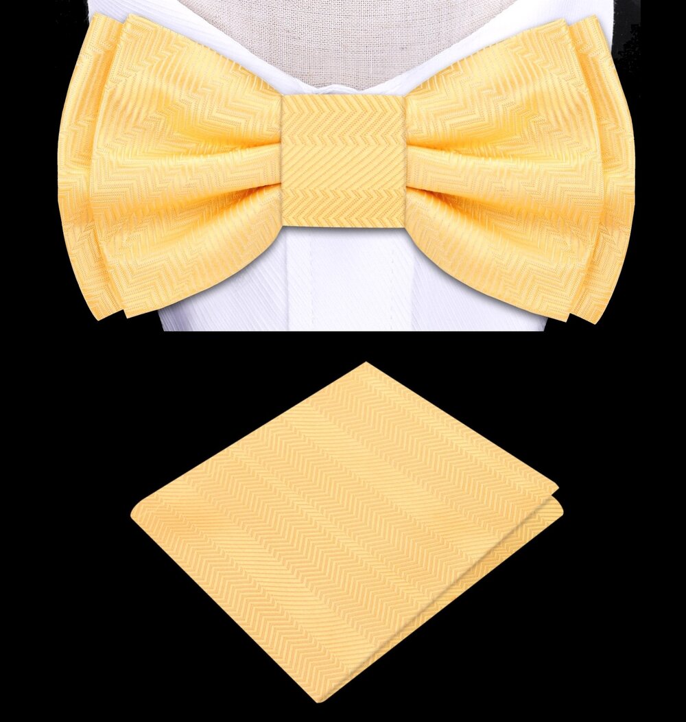Dandelion yellow silk bow tie and pocket square set on a wooden table, showcasing the vibrant color and luxurious texture.