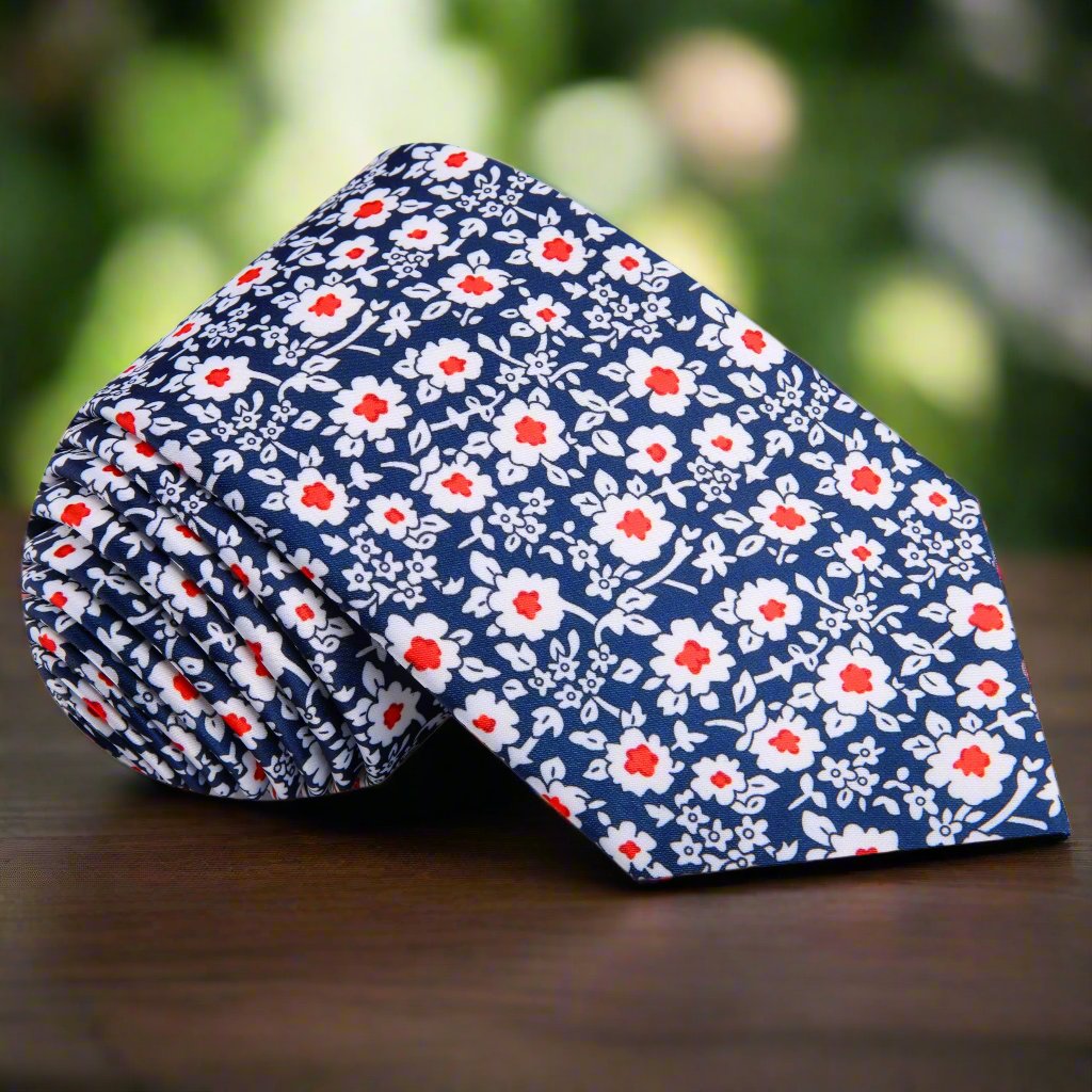 Close-up of the elegant blue and red floral silk necktie showcasing intricate flower patterns, perfect for a wedding.