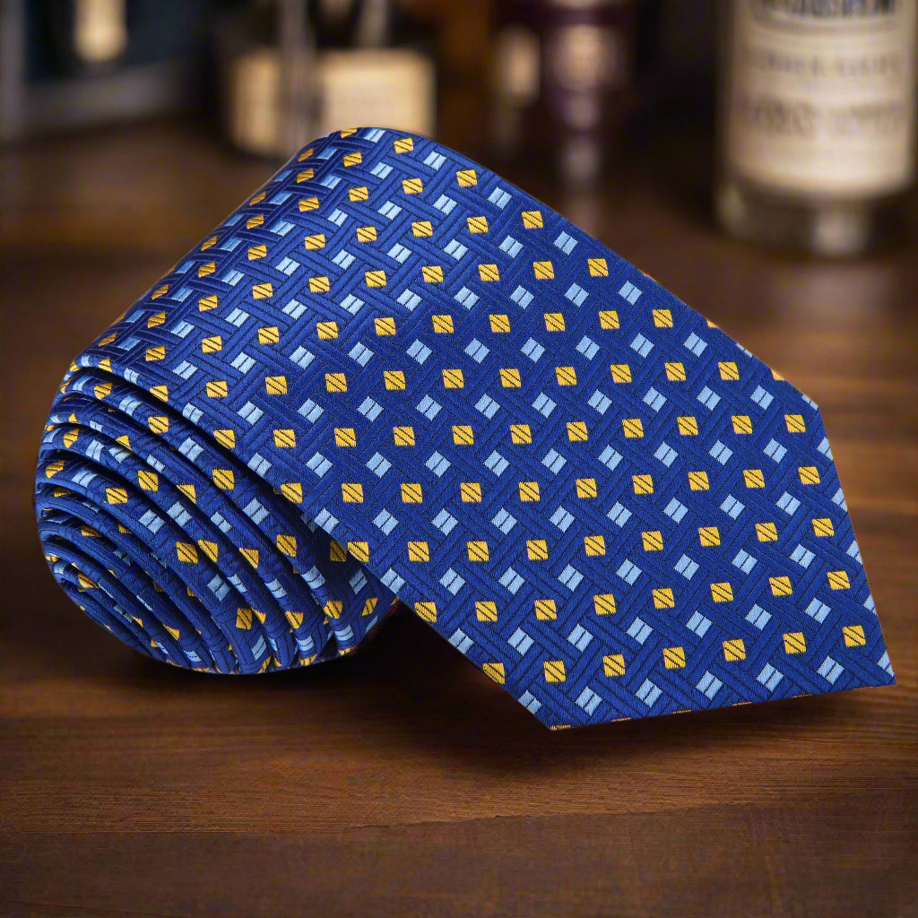 Elegant blue geometric necktie displayed on a white dress shirt, highlighting its vibrant patterns.