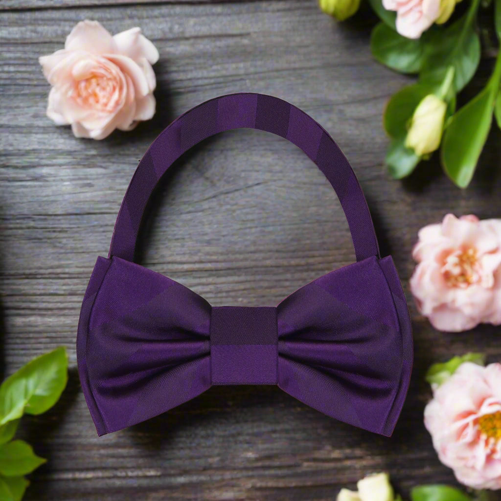 Close-up of the Noble Stripe Silk Bow Tie showcasing its rich purple color and stripe pattern.