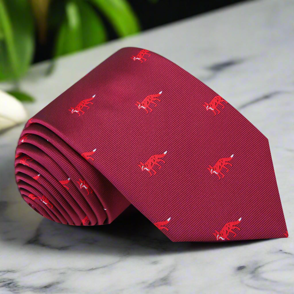 Close-up view of the charming fox pattern on the red silk necktie, showcasing the rich colors.