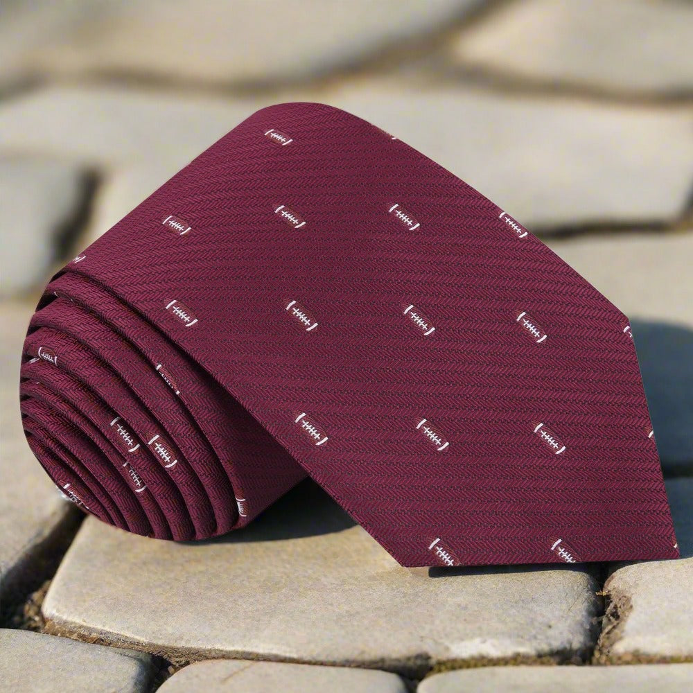 Silk necktie featuring American football pattern on blue fabric, ideal for casual dress code