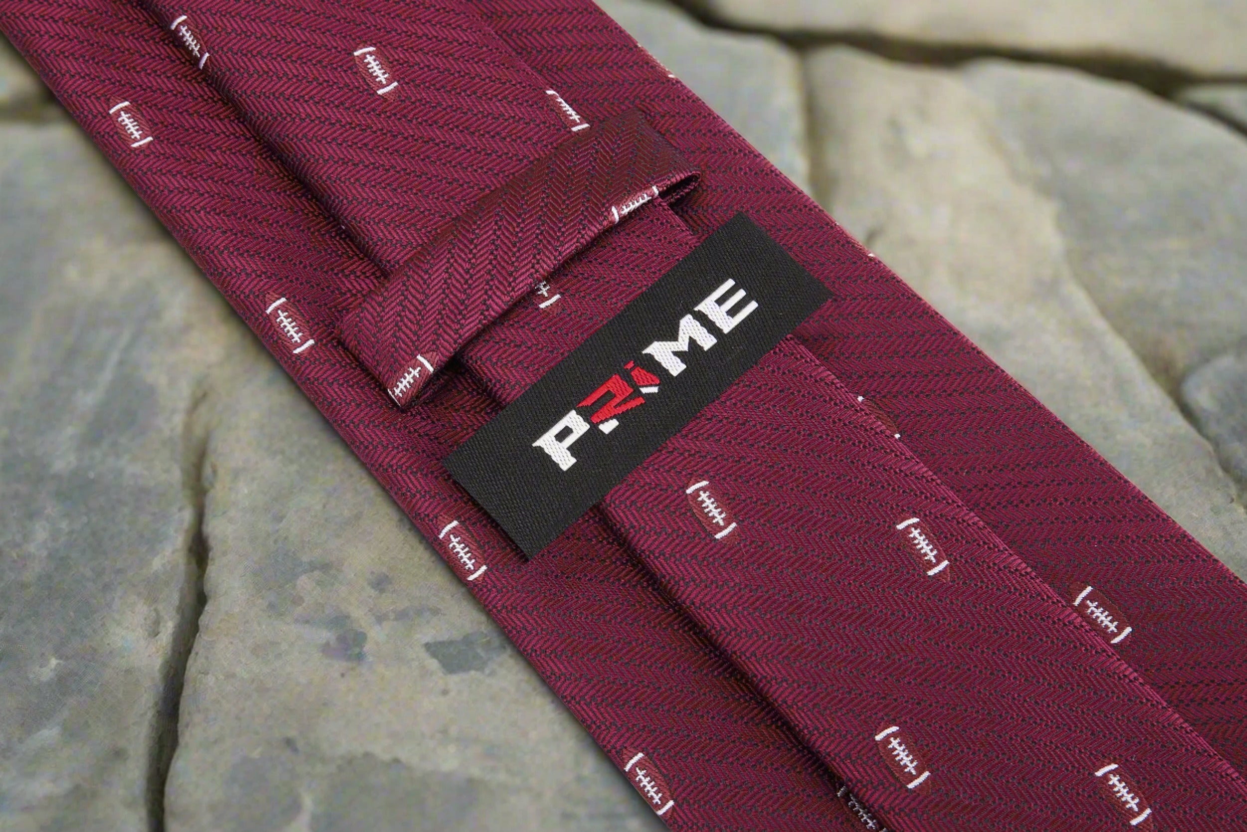 Close-up of football-themed silk necktie with vibrant blue background, perfect for game day parties