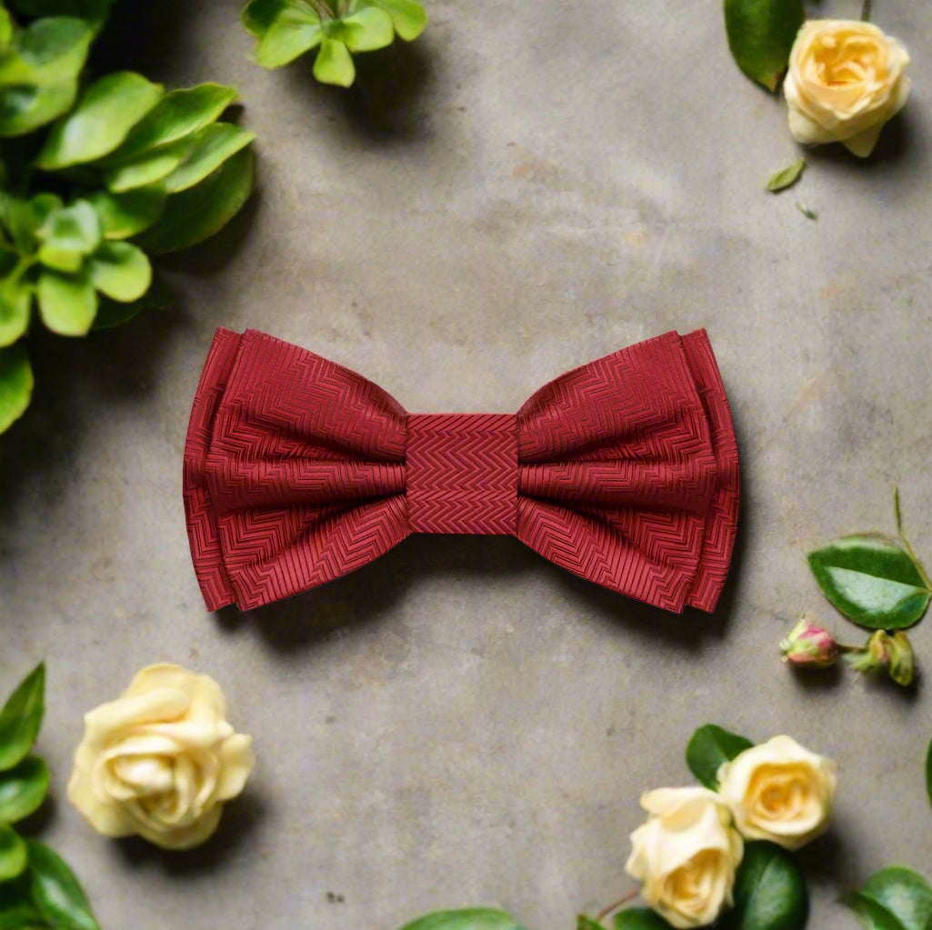Elegant garnet red silk bow tie displayed on a classic white dress shirt, highlighting the texture and color contrast.
