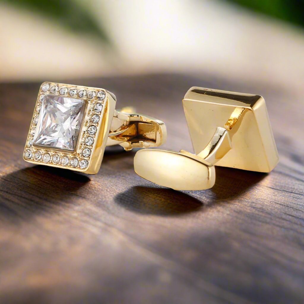Close-up view of elegant gold cufflinks with clear stones, showcasing their intricate design.