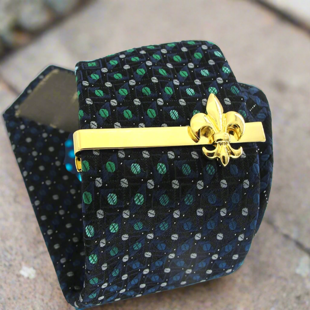 Elegant gold fleur de lis tie clip against a white dress shirt, showcasing its sophisticated design.