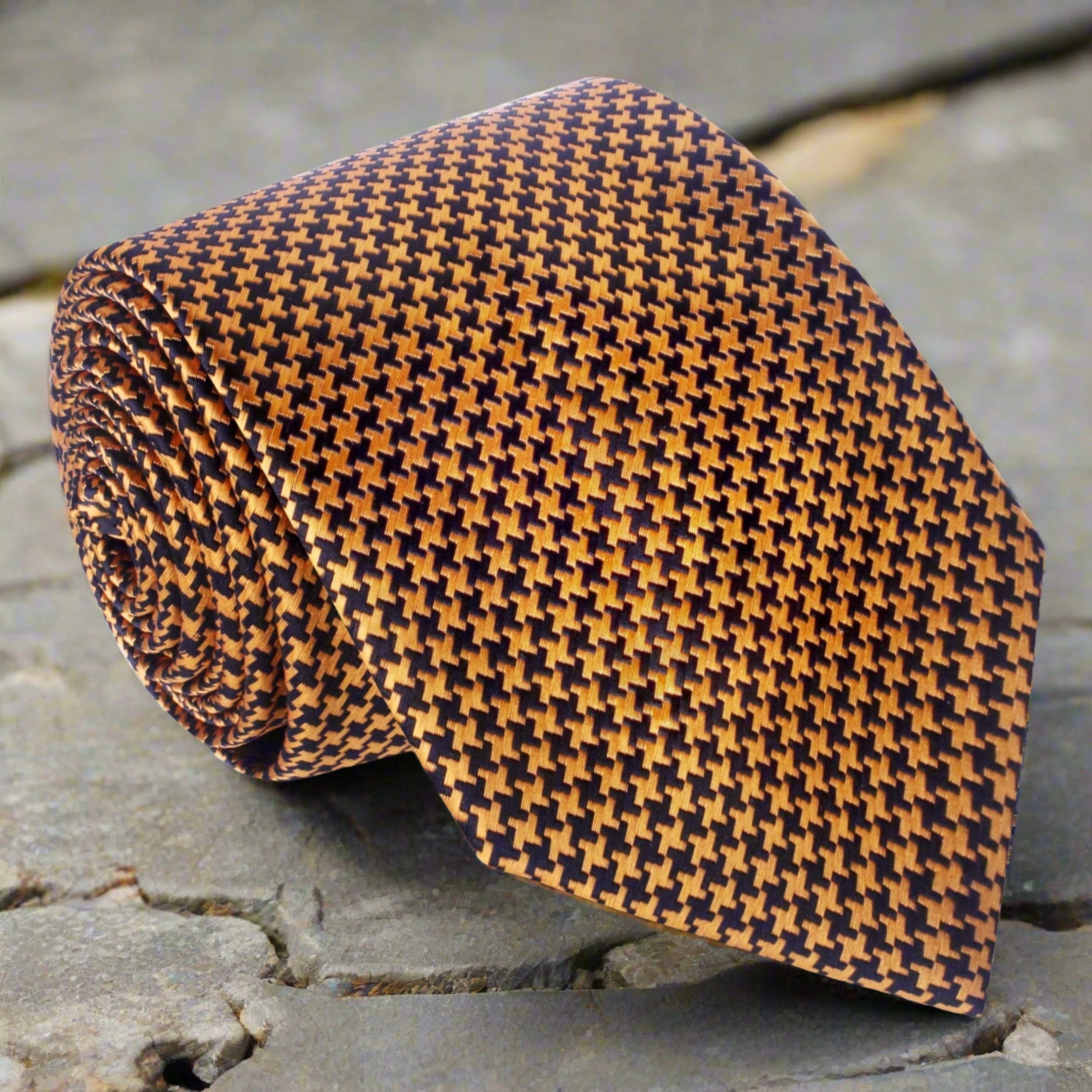 Close-up view of the metallic gold houndstooth silk necktie showcasing its elegant design.