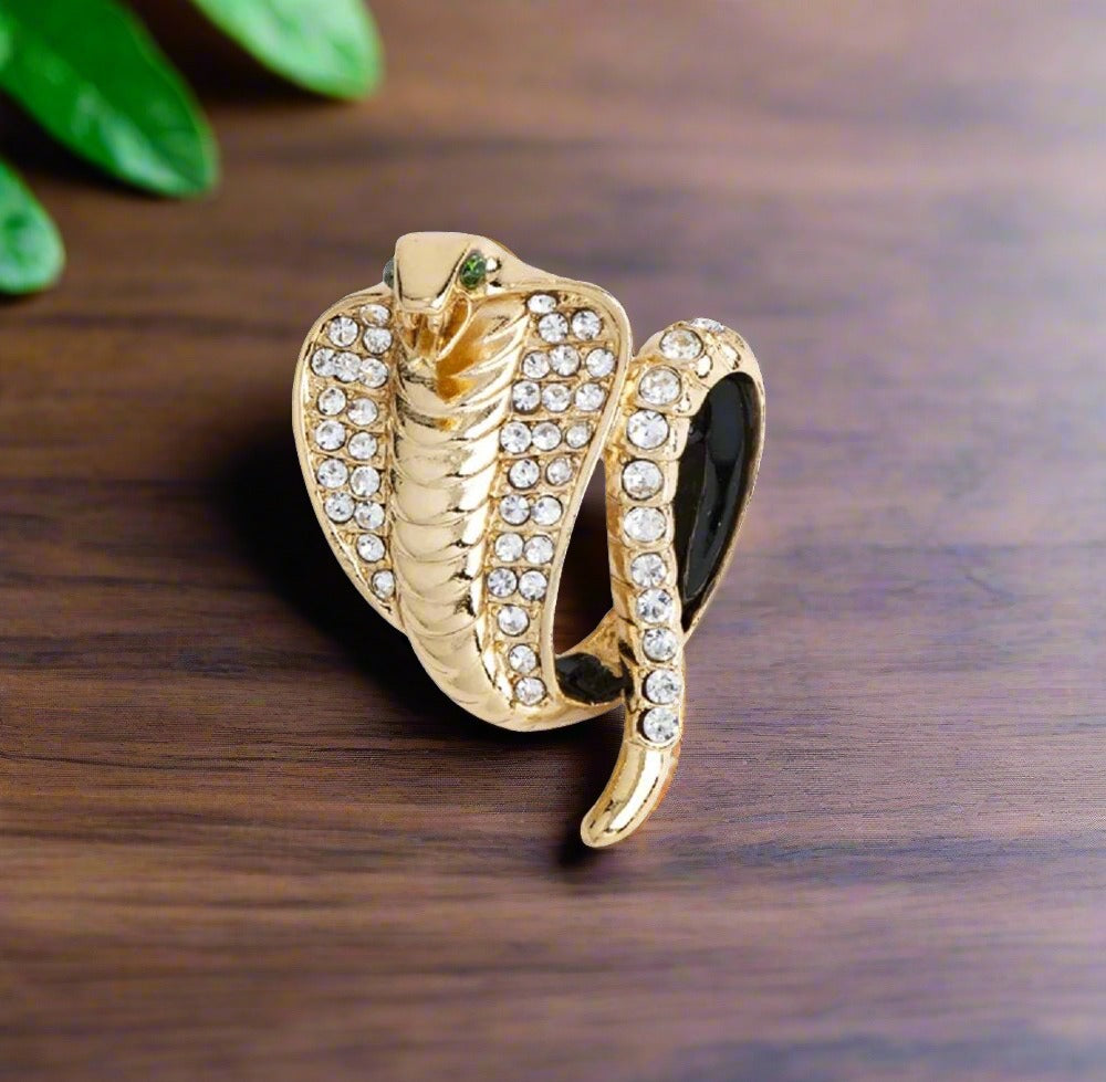 Close-up of gold cobra lapel pin with clear stones on a white dress shirt