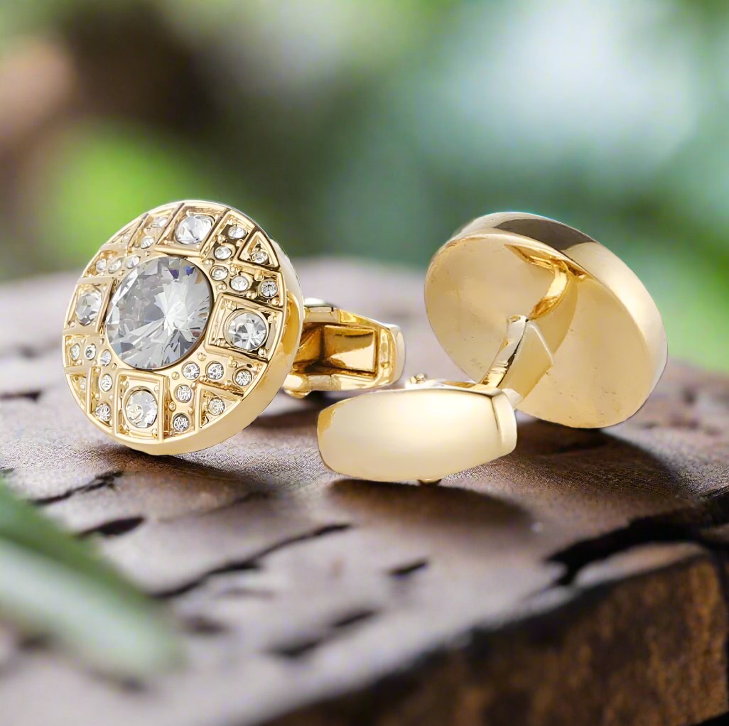 Close-up view of elegant gold cufflinks with clear stones, showcasing their intricate design.