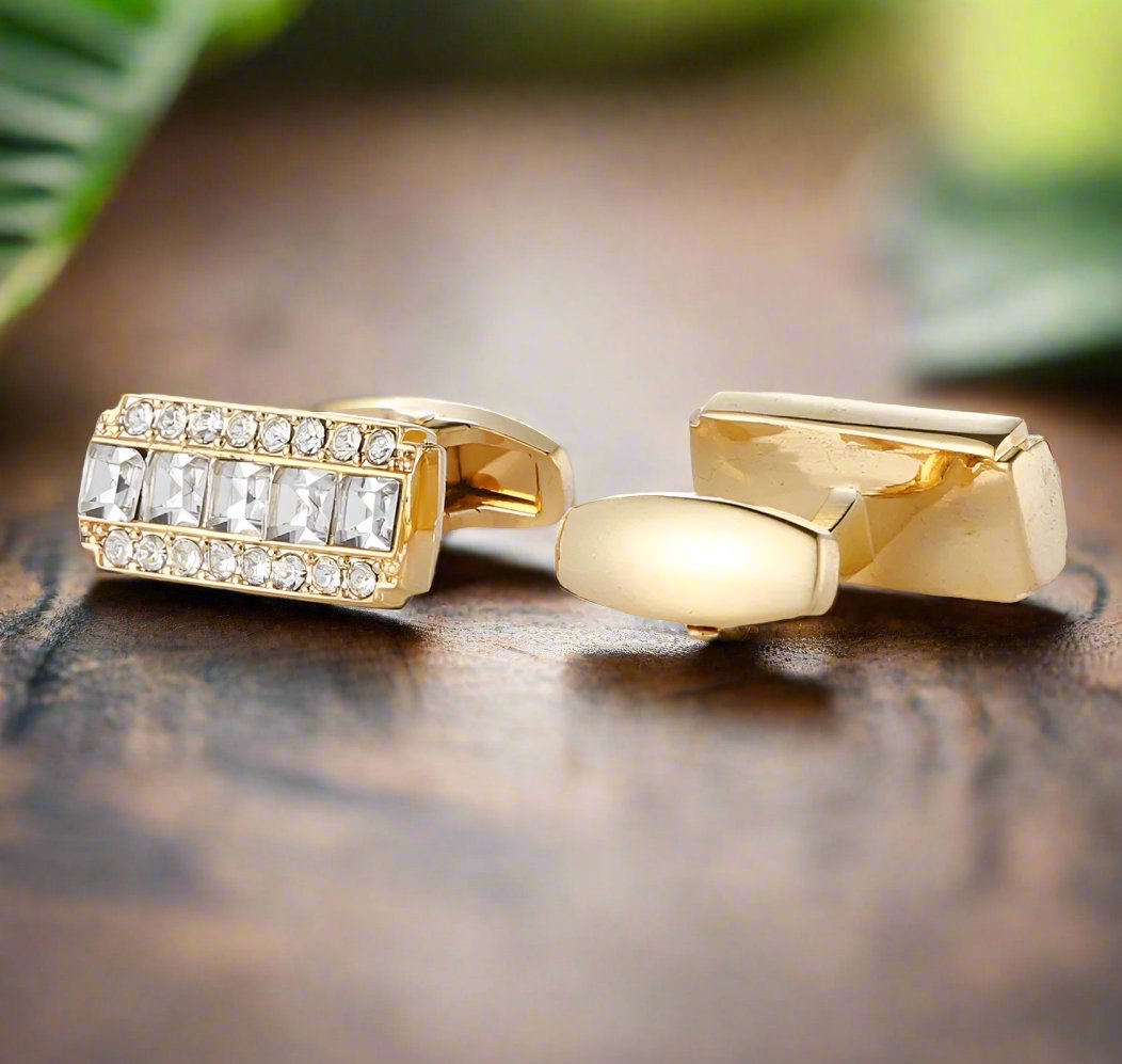 Gold cufflinks with clear stones paired with a classic white dress shirt, ideal for formal events.