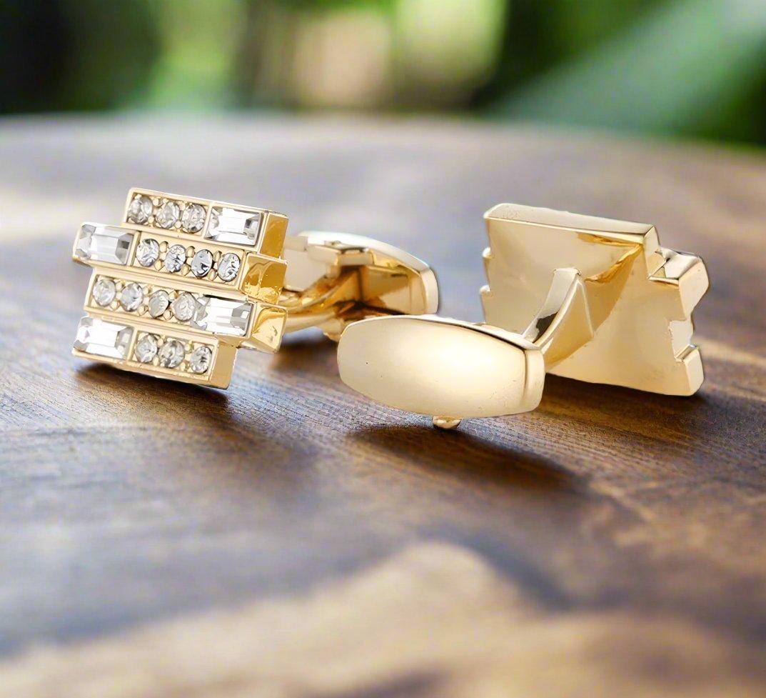 Gold cufflinks with clear stones paired with a classic white dress shirt, ideal for formal events.