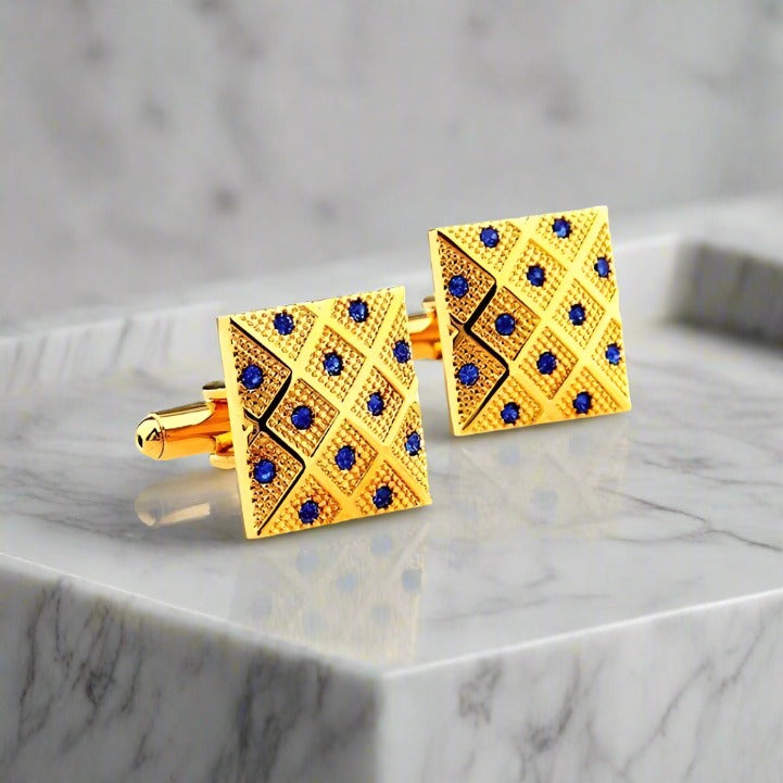 Gold and blue gem cufflinks displayed on a pale pink shirt — ideal for weddings or gala dinners.