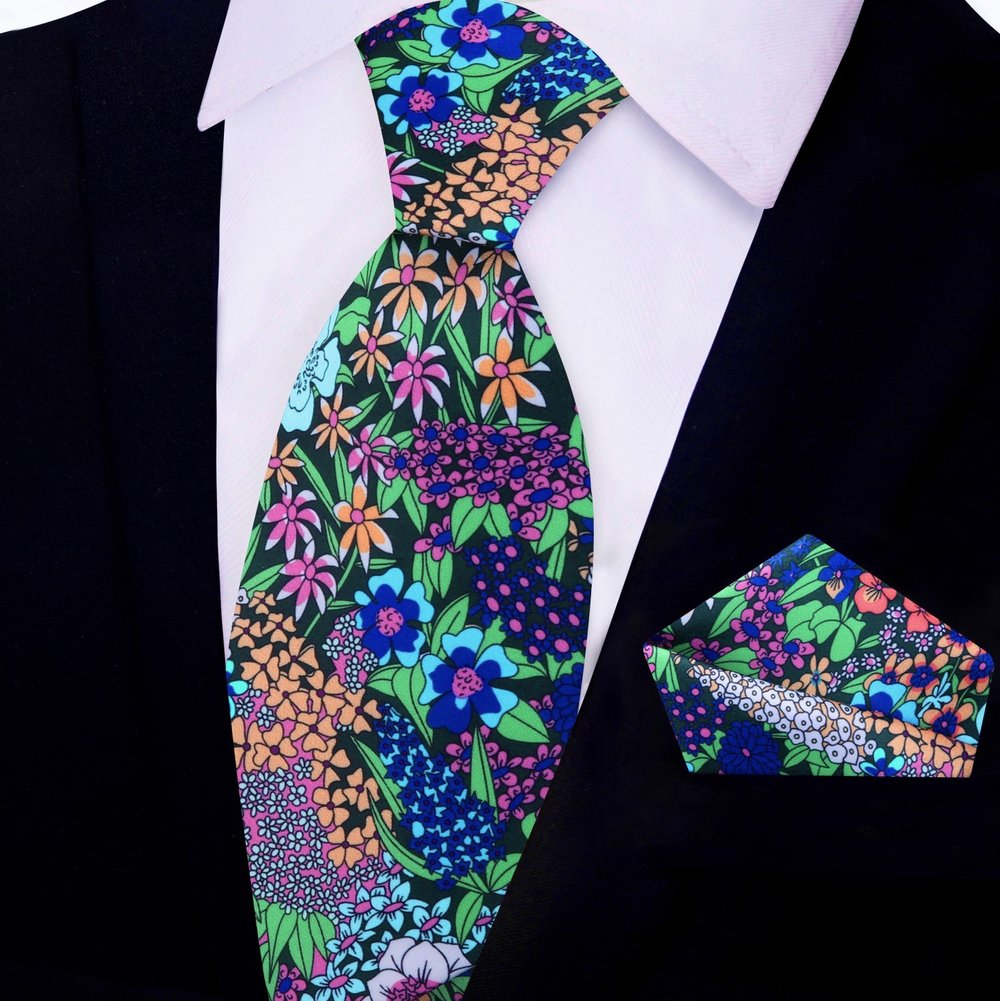 Close-up of vibrant floral silk tie with botanical pattern in green, purple, and pink