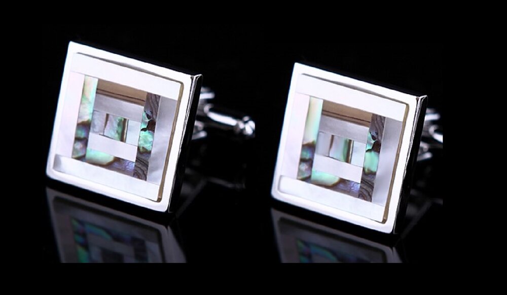 Close-up of square cufflinks with off white shell black accents, showcasing luxury craftsmanship.