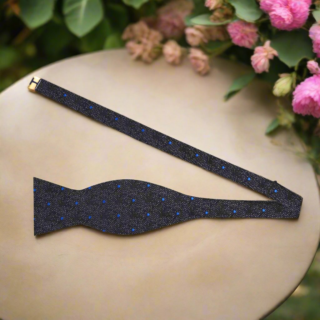 Charcoal elegance bow tie with blue dots displayed on a white dress shirt