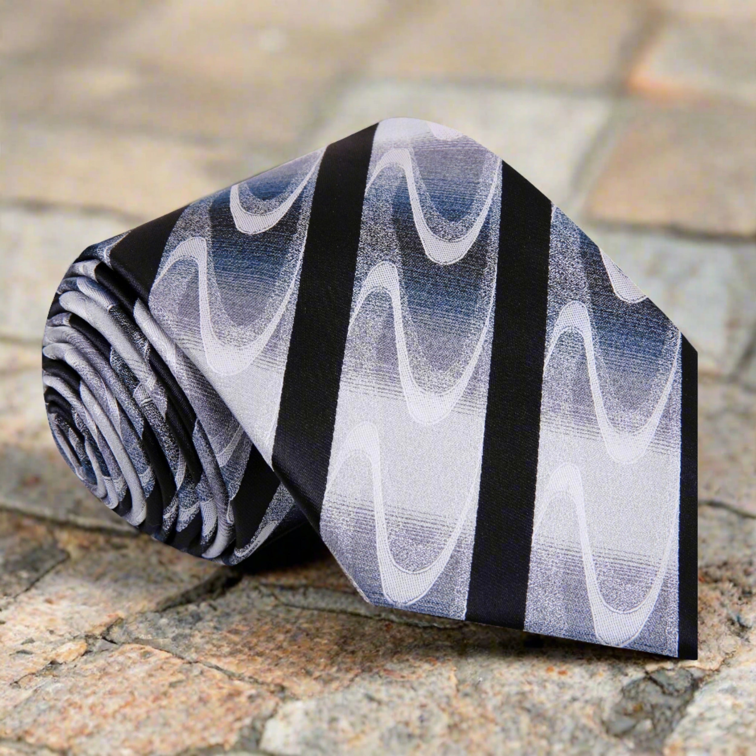 Rothmere striped silk necktie on a grey suit, highlighting the abstract wave pattern.