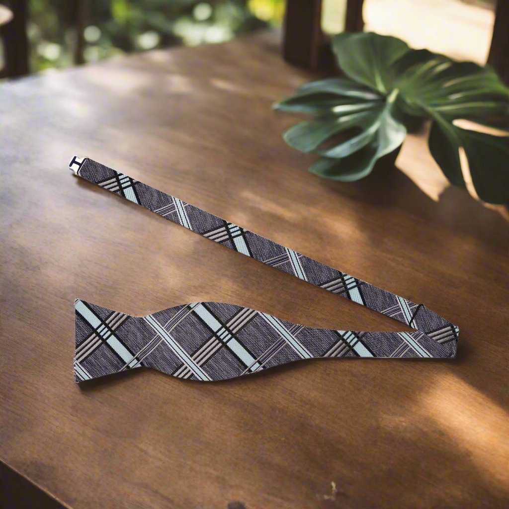Elegant grey plaid silk bow tie displayed on a formal shirt for weddings.