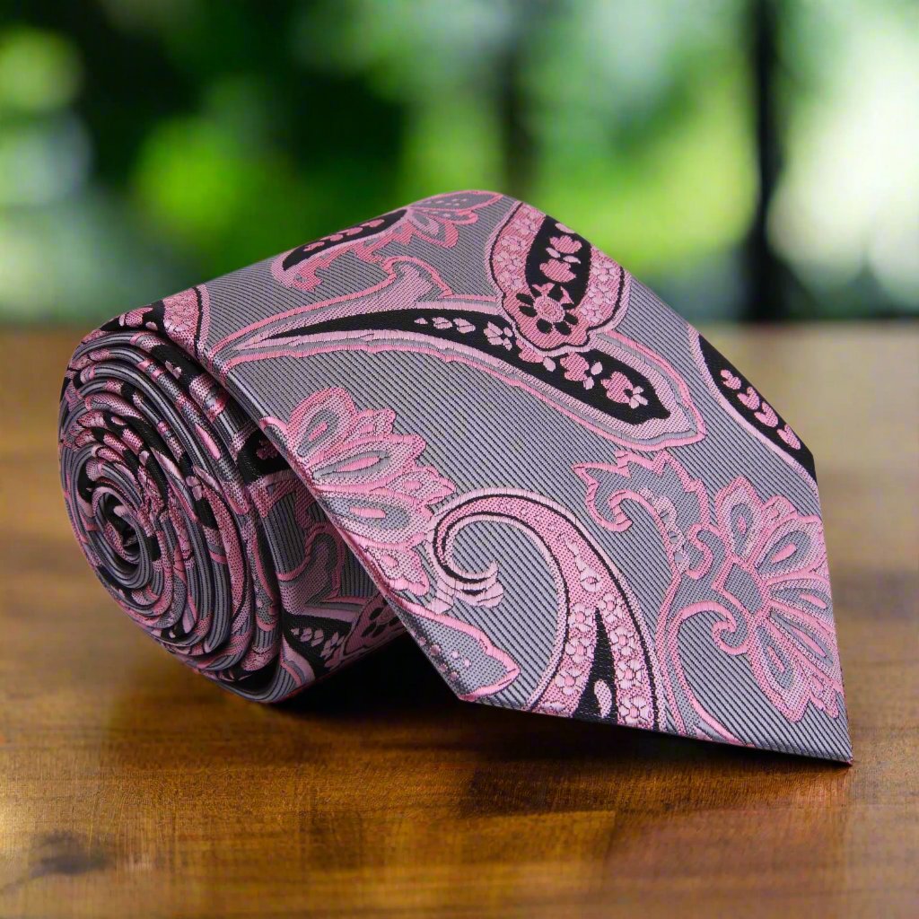 Detailed view of the elegant paisley necktie showcasing silver, pink, and black colors.
