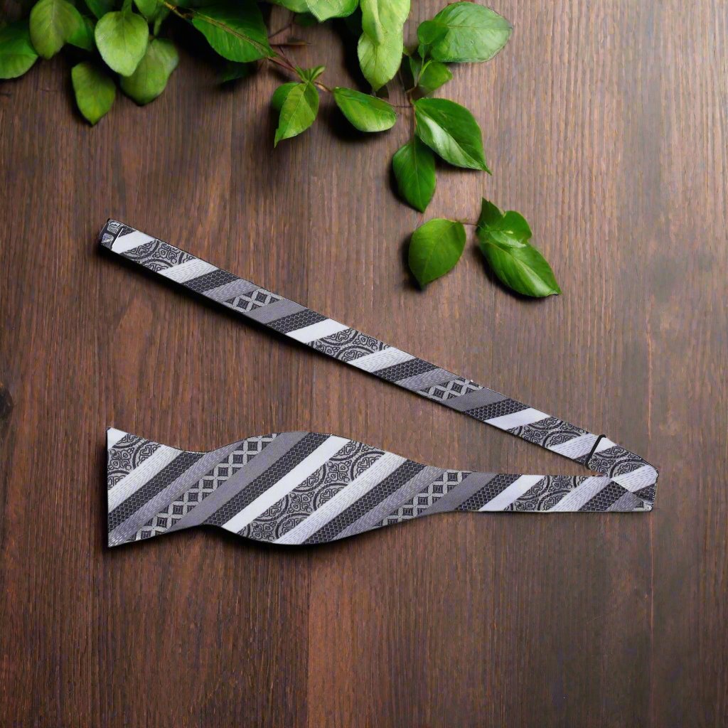 Close-up of grey silk self-tie bow tie with abstract pattern for formal wear