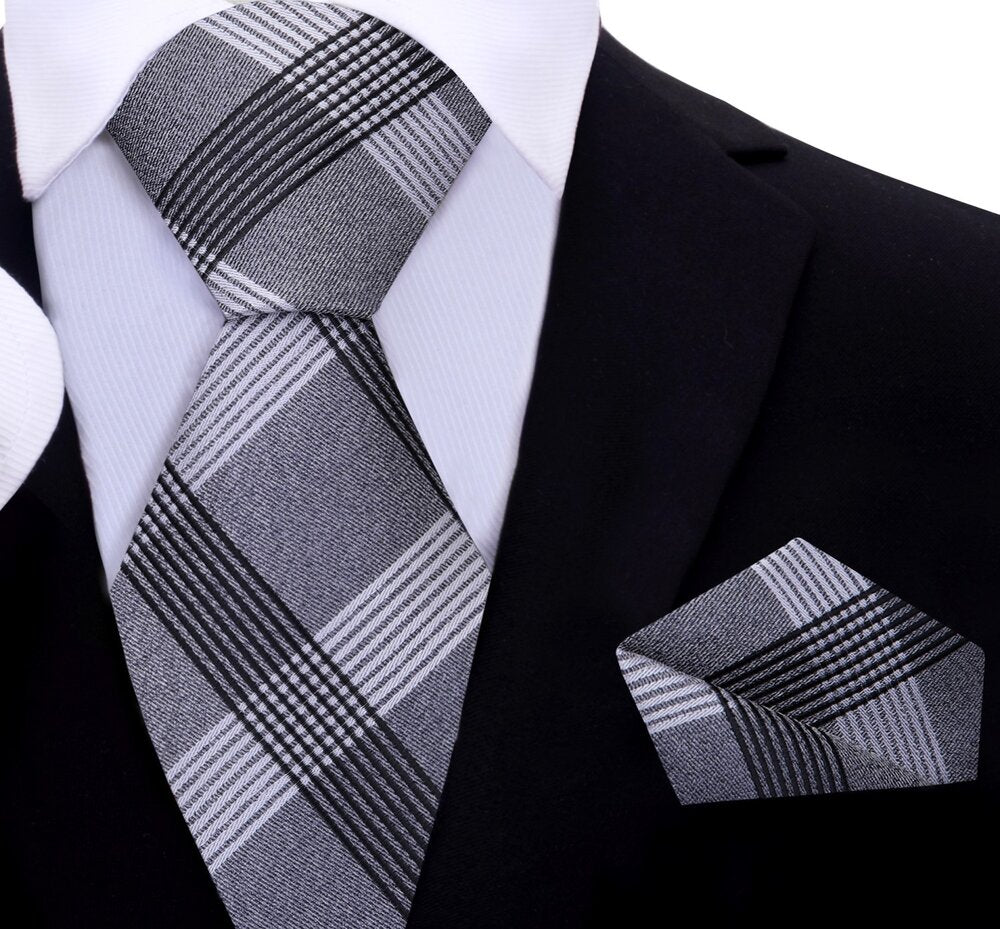 Front view of a mens silk plaid tie in grey, white, and black