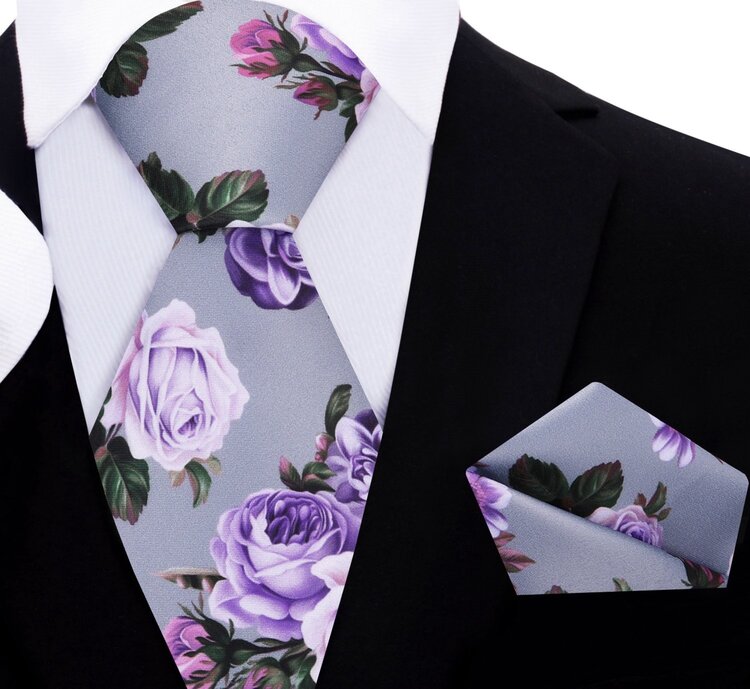 Close-up of the floral print necktie, highlighting the vibrant pink roses against a rainy day gray background.