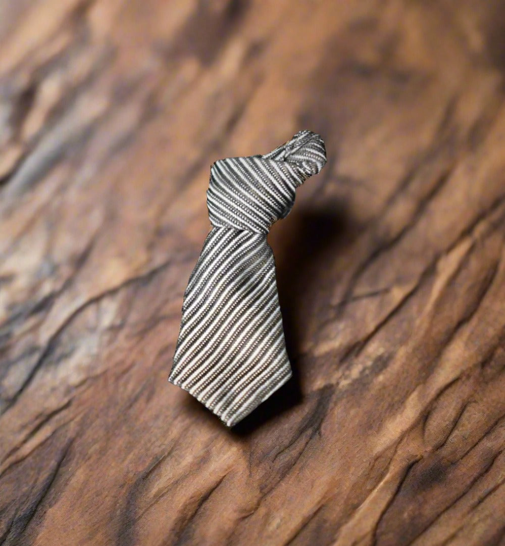 Charming necktie lapel pin displayed on a white dress shirt, showcasing its unique design.