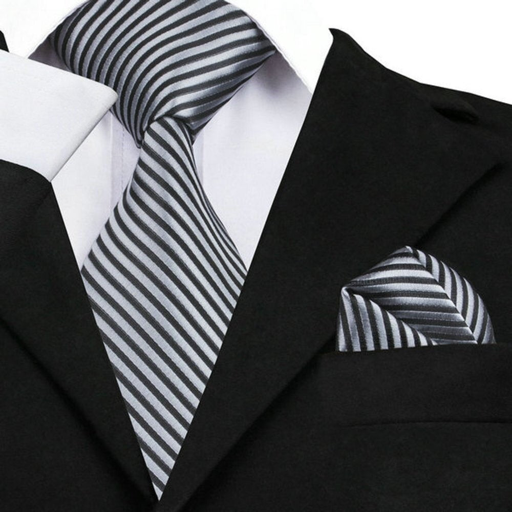 Close-up view of the elegant silk necktie and pocket square set, showcasing the black and silver pinstripe design.