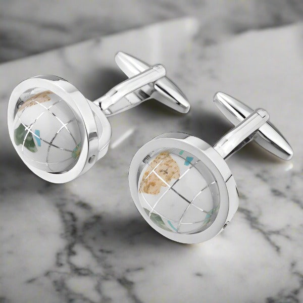 Close-up of luxury globe cufflinks showcasing intricate blue and white details.