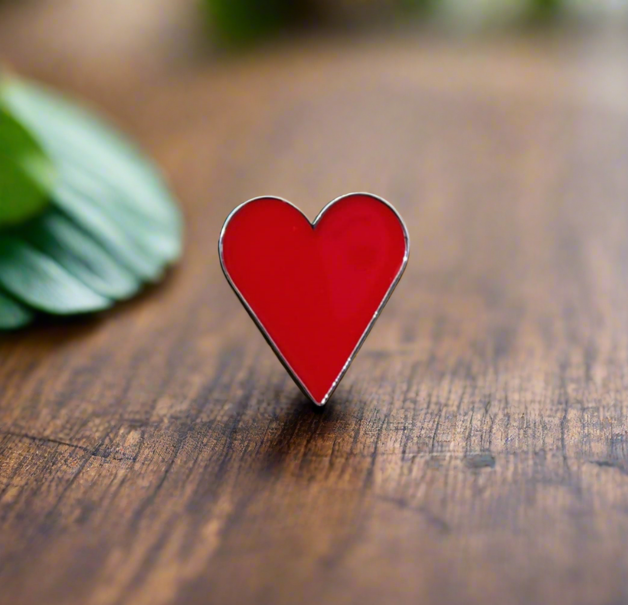 Close-up view of the charming heart-shaped lapel pin on a blazer.