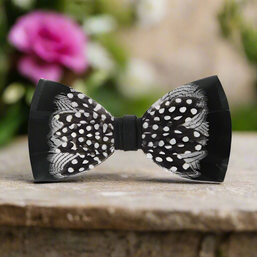Close-up of black feather bow tie with white accents, ideal for formal accessories